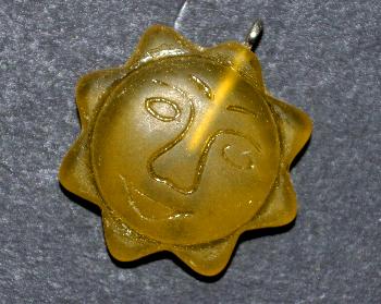 Glasanhänger mit Öse,
 Sonnenornament im Halbrelief dargestellt, gelb transparent mattiert 